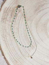 Cargar imagen en el visor de la galería, Collar oro doble con cadena de rosario oro mate y cristal turquesa 3x2mm. Cadena de 0,7mm bañada en oro y lágrima facetada 8x5mm, de 37cm con extensión.