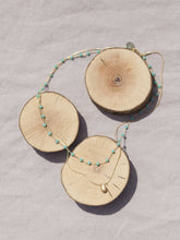 Cargar imagen en el visor de la galería, Collar oro doble con cadena de rosario oro mate y cristal turquesa 3x2mm. Cadena de 0,7mm bañada en oro y lágrima facetada 8x5mm, de 37cm con extensión.