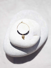 Cargar imagen en el visor de la galería, Pendientes de aro de 30mm bañados en Oro con detalle de hoja 15x7mm Oro mate y cristal facetado de 2mm negro.