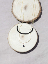 Cargar imagen en el visor de la galería, Collar oro doble negro con detalle lágrima esmaltada con cadena doble, una sencilla de 0,7mm y otra con cristal negro de 2mm y 37 cm de largo con extensión.