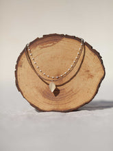 Cargar imagen en el visor de la galería, Collar oro hoja rosario doble 21x11mm oro mate, cadena de rosario blanco 3x2mm, hilo de acero con cristal vison 2mm y un largo de 39 cm con extensión.