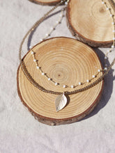 Cargar imagen en el visor de la galería, Collar oro hoja rosario doble 21x11mm oro mate, cadena de rosario blanco 3x2mm, hilo de acero con cristal vison 2mm y un largo de 39 cm con extensión.