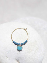 Cargar imagen en el visor de la galería, Aros de 20mm bañados en Oro con detalle de pieza circular esmaltada 8mm azúl y cristal facetado de 2mm verde mar.