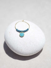 Cargar imagen en el visor de la galería, Aros de 20mm bañados en Oro con detalle de pieza circular esmaltada 8mm azúl y cristal facetado de 2mm verde mar.