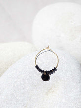 Cargar imagen en el visor de la galería, Aros de 20mm bañados en Oro con detalle de pieza circular esmaltada 8mm negro y cristal 2mm negro.