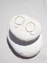 Cargar imagen en el visor de la galería, Aros de 20mm bañados en Oro con detalle de pieza circular esmaltada 8mm blanco y cristal 2mm blanco Opal.
