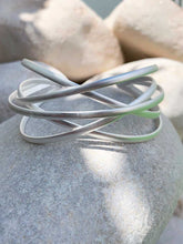 Cargar imagen en el visor de la galería, Brazalete plata entrelazado pequeño, brazalete bañado en plata mate de tiras entrelazadas entre si de 3,5cm en su arte mas ancha.
