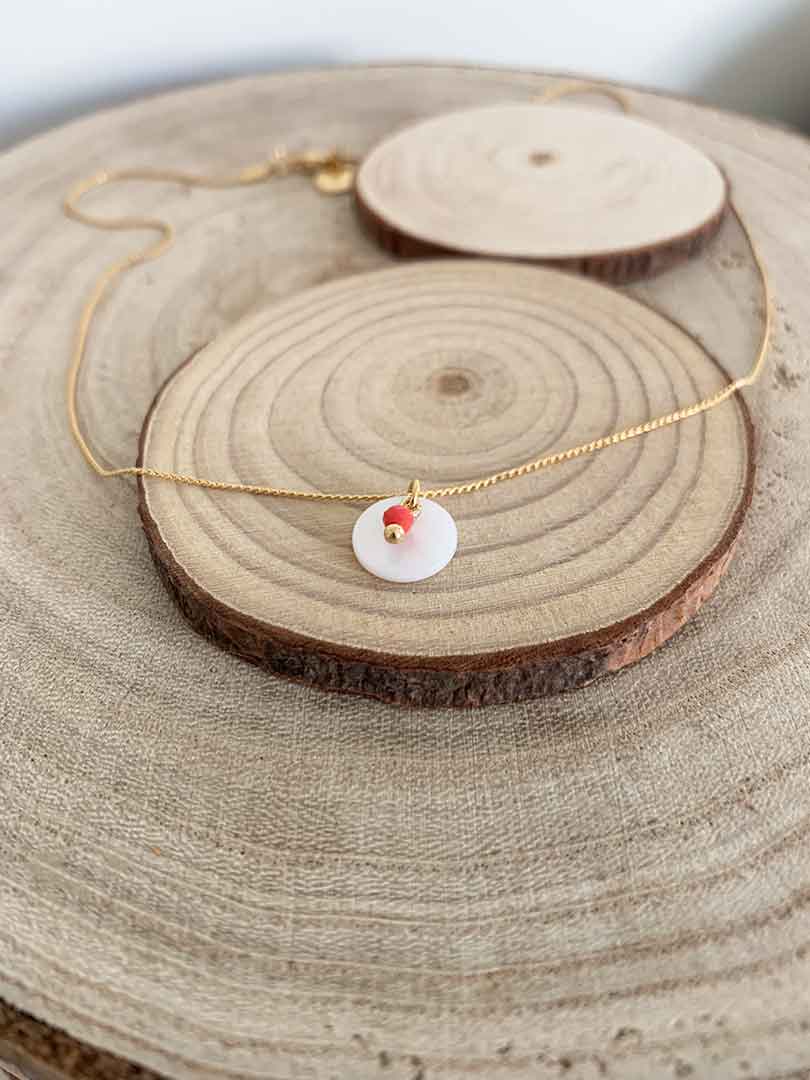 Collar oro nacar bolita coral de 2mm y chapita de nácar de 10mm con cadena sencilla de 0,7mm bañada en oro y un largo de 37cm con extensión.