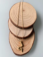 Cargar imagen en el visor de la galería, Collar oro culebra mate, con cadena sencilla de 0,7mm bañada en oro y con pieza central de culebra de 16x9mm oro mate y extensión para diferentes medidas.
