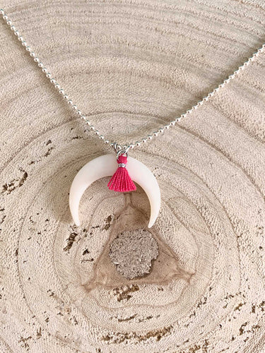 Collar plata media luna nacar de 25x5mm con cadena de bolitas de 1,2mm bañada en plata brillo de 42cm de largo y detalle de pompon en fucsia con extensión.